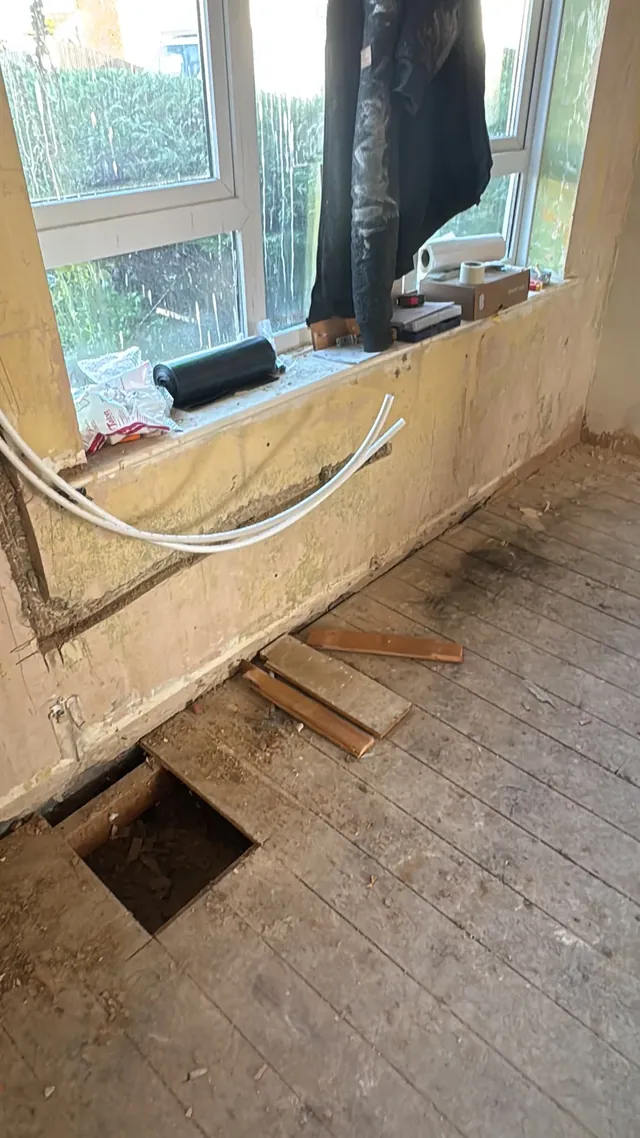 Exposed floorboards and floor access during early preparation