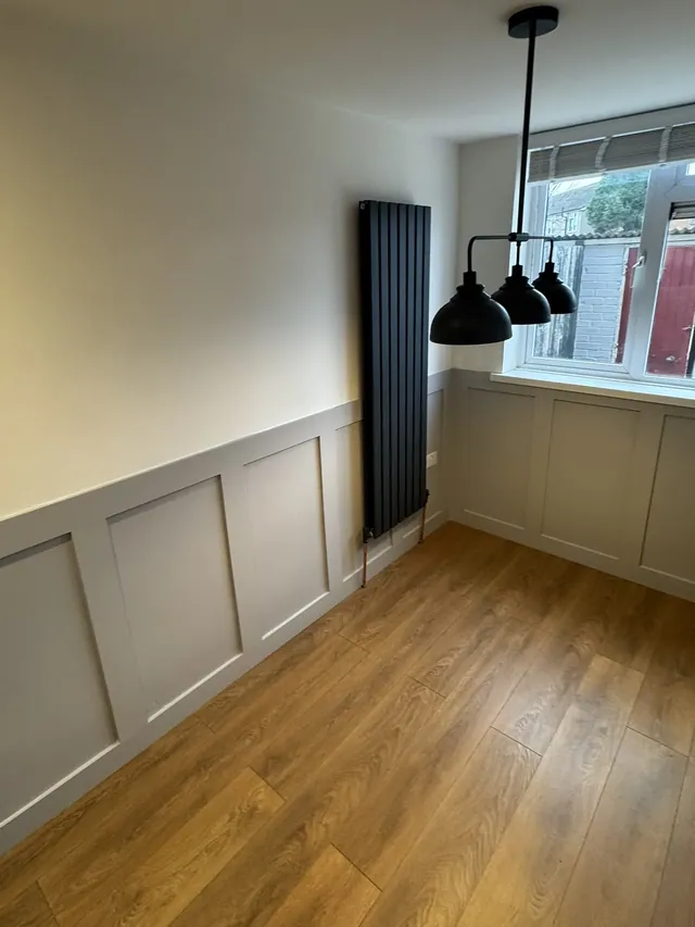 Finished dining area with pendant lights and a vertical radiator