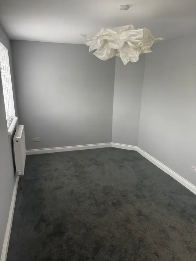 Decorated bedroom with fitted carpet and window blind