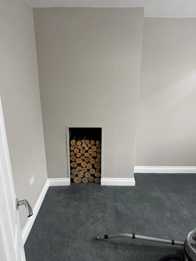 Decorated bedroom fireplace wall and fitted carpet