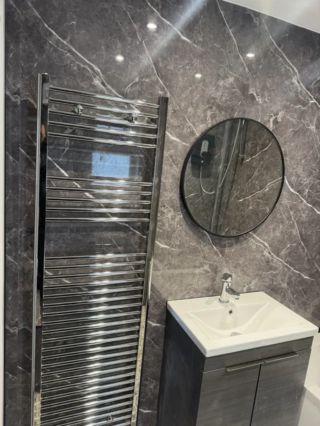 Bathroom vanity unit, round mirror and heated towel rail