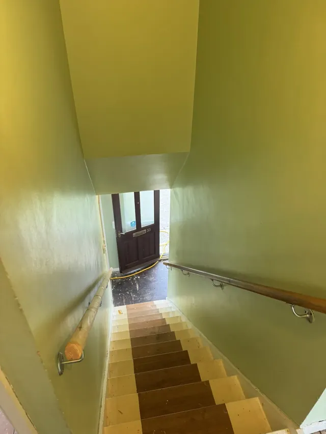 Staircase and yellow-painted walls before refurbishment