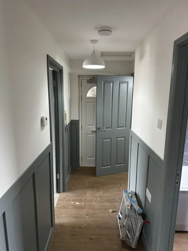 Decorated hallway with painted wall panelling and doors