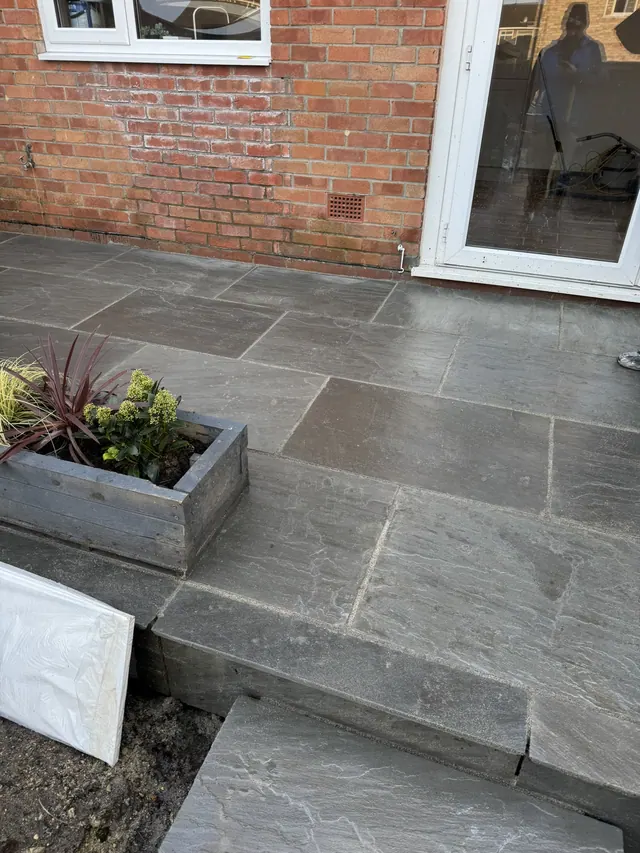 Later view of the paved patio, access steps and raised-bed edging