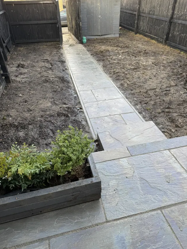 New paved patio and garden path with raised planting beds